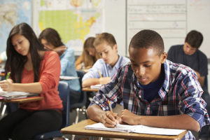 student in classroom writing